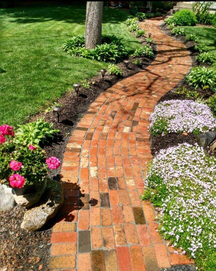 Brick garden path edged with flowering perennials