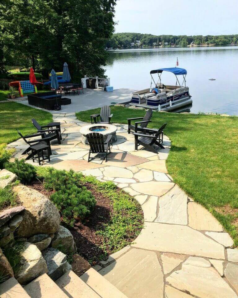 Lakeside flagstone patio and garden beds with a dock