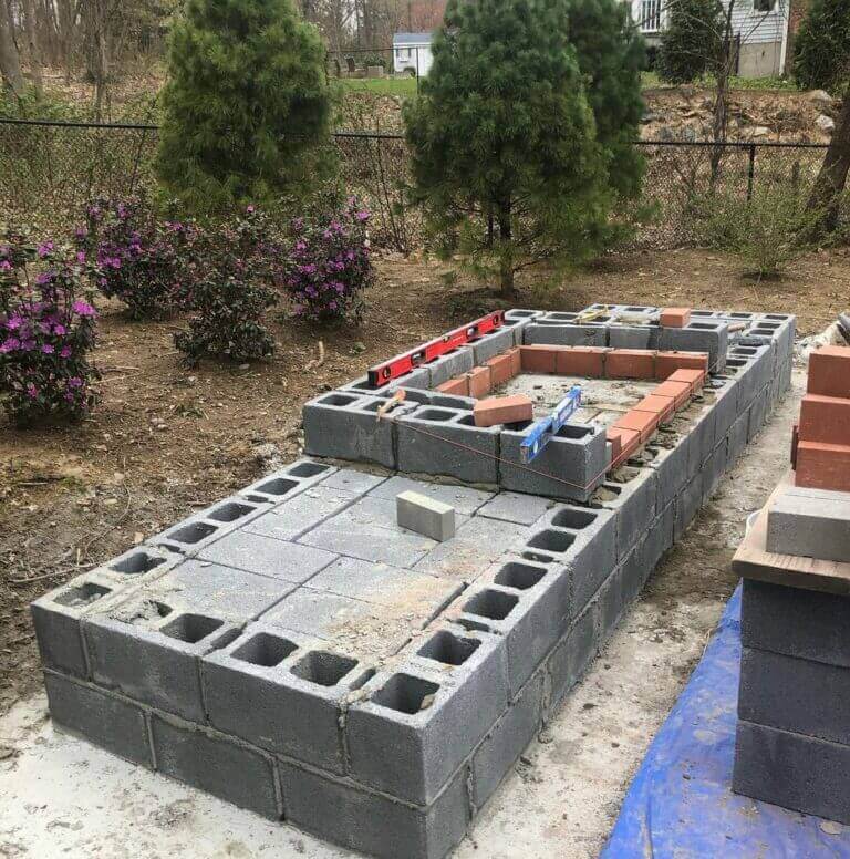 Concrete block outdoor kitchen frame on a new paver patio
