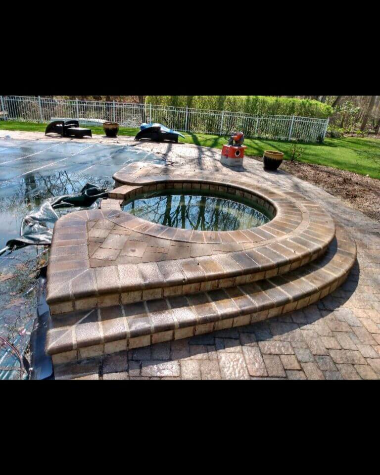 Curved stone steps leading to a round patio, side view