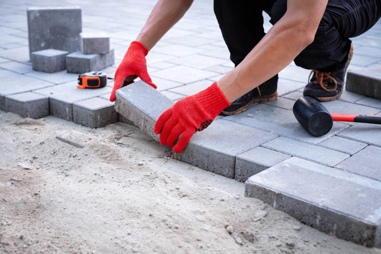 Master In Yellow Gloves Lays Paving Stones